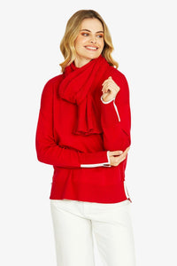 Red knit pullover styled with matching scarf showing almond tipped sleeve details